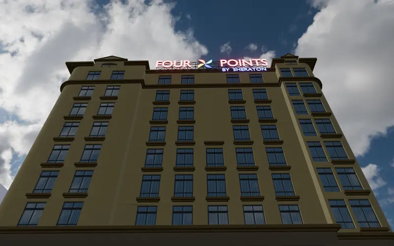 City hotel facade with lit crown signage at night