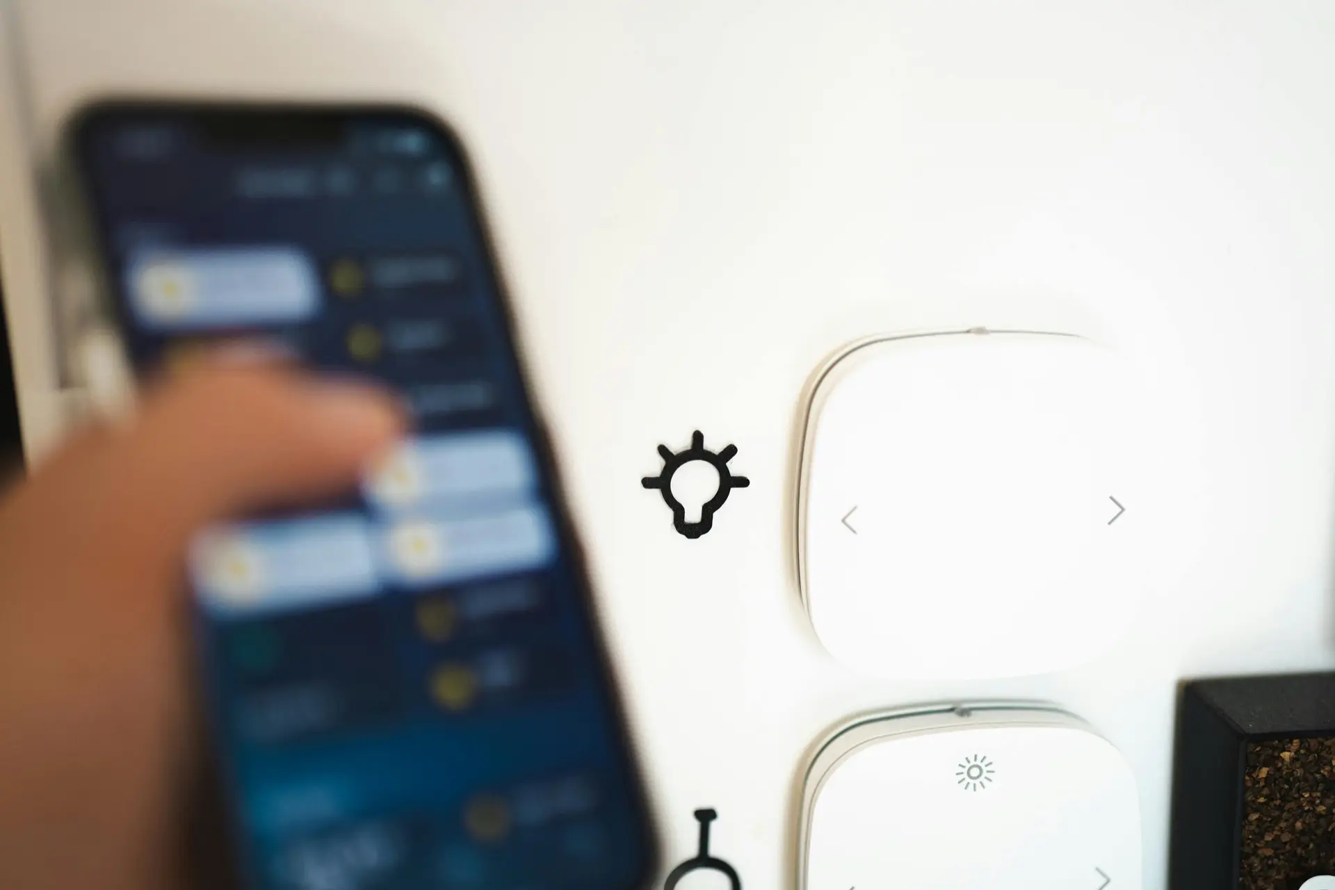 A hand holding a phone controlling the room’s lights from one app