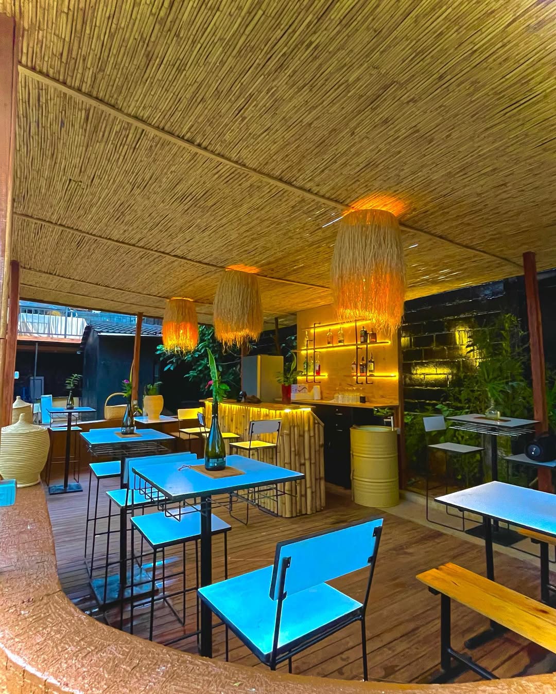 Open-air restaurant with thatched ceiling and warm mood lighting
