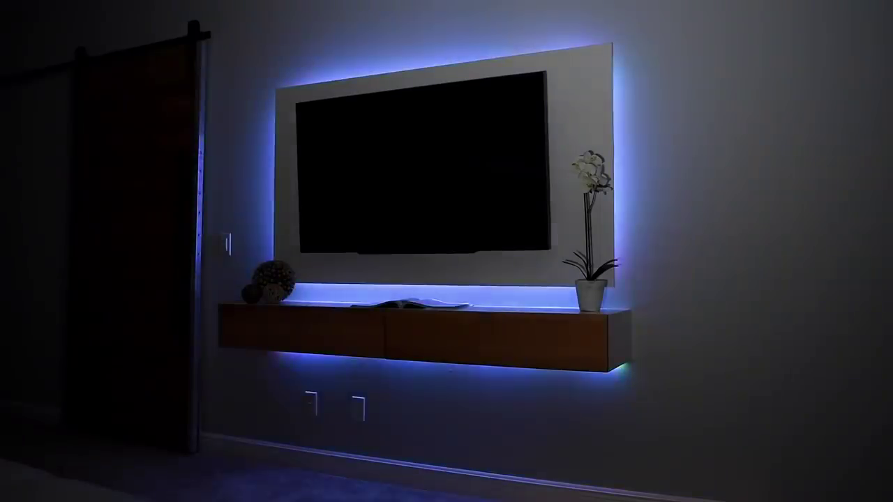 TV with blue ambient backlighting against wood panel